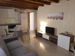 a kitchen and a living room with a table and a television at Elly's House in Verona