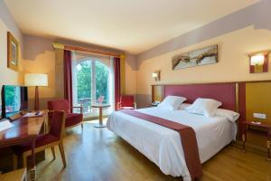 a hotel room with a large bed and a desk at Hotel Fuente Las Piedras in Cabra
