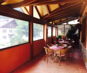 an outdoor patio with tables and chairs and windows at Hotel Miramonti in Pinzolo