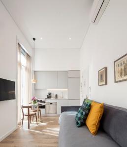 a living room with a couch and a kitchen at Lisbon Serviced Apartments - Chiado Emenda in Lisbon
