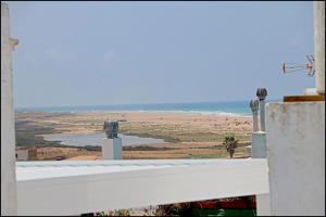 a view of the beach from a balcony of a building at Apartamento Velarde III in Conil de la Frontera