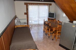 a living room with a dining room table and a television at Cabaña Maitén in San Carlos de Bariloche