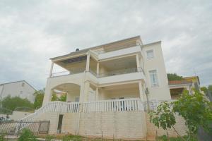 una grande casa bianca con un ampio balcone di Apartment Bilice beach a Bilice (Bilizze)