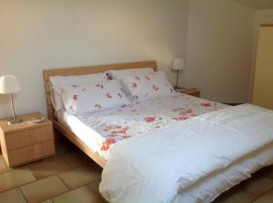 Un dormitorio con una cama blanca con flores. en Al numero61, en Viverone