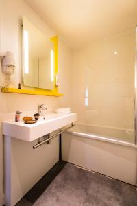 a bathroom with a sink and a shower and a tub at Ibis Styles Rouen Centre Cathédrale in Rouen