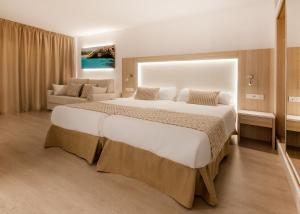 a bedroom with a large bed and a living room at Globales Costa de la Calma in Santa Ponsa