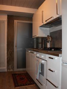 a kitchen with white cabinets and a stove top oven at Casa enzo in Arezzo