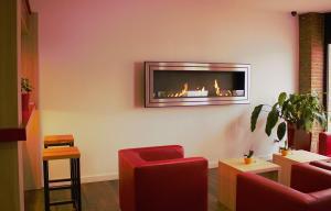 a living room with a fire place on the wall at Montivo Hotel Köln-Bonn Airport - ehemals Montana Hotel in Troisdorf