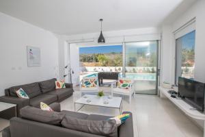 ein Wohnzimmer mit einem Sofa und einem TV in der Unterkunft Greco Villas in Protaras