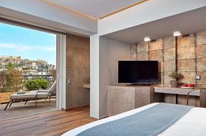 a bedroom with a bed and a tv and a balcony at 18 Micon Str. in Athens