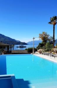 a large blue swimming pool with a view of the water at Hotel Domaso in Domaso