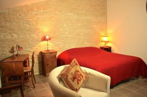 - une chambre avec un lit rouge et une chaise dans l'établissement Les chambres de Blanot, à Blanot