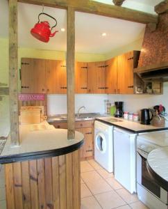 a kitchen with a washing machine and a red light at lesChenes in Saint-Dolay +25 photos