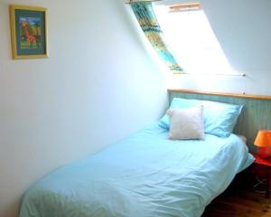 a bedroom with a blue bed with a light on it at lesChenes in Saint-Dolay