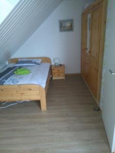 a bedroom with a wooden bed and a wooden door at Ferienhaus "Buchfink" in Berumbur