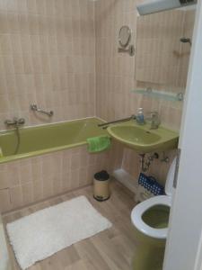 La salle de bains est pourvue d'une baignoire verte et de toilettes. dans l'établissement Ferienhaus "Buchfink", à Berumbur