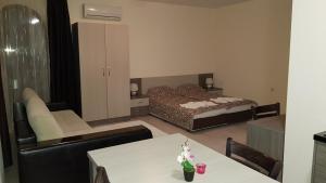 a living room with a bed and a table and chairs at Brilliant Aparthotel in Sozopol +30 photos