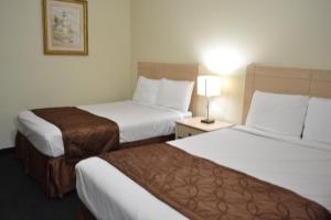 a hotel room with two beds and a lamp at Passport Inn Niagara Falls in Niagara Falls