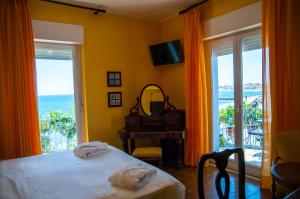 a bedroom with a bed and a view of the ocean at Hotel Palladio in Giardini Naxos