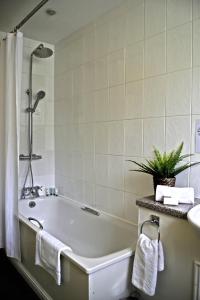 a bathroom with a bath tub and a sink at Bridge of Cally Hotel in Blairgowrie