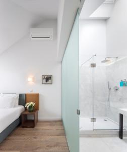 um quarto com um chuveiro, uma cama e uma banheira em Lisbon Serviced Apartments - Chiado Emenda em Lisboa