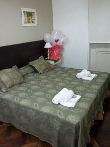 1 dormitorio con 1 cama con 2 toallas y globos en Plaza Hotel en Salta