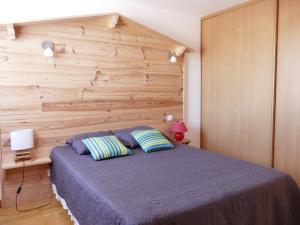 ラ・コティニエールにあるMa Chaumiereの木製の壁のベッドルーム1室(ベッド1台付)
