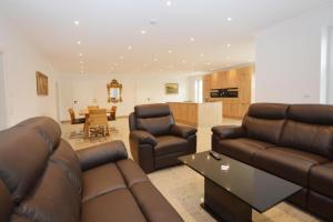 ein Wohnzimmer mit 2 Sofas und einer Küche in der Unterkunft Ferienhaus Merzijana in Büsum