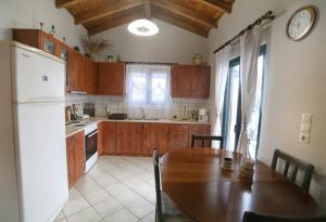 a kitchen with a table and a white refrigerator at Villa Tsouredo in Agios Kirykos