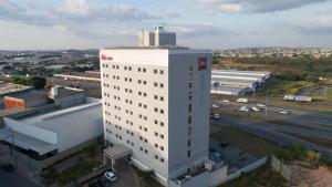 孔塔任宜必思康塔奇撒酒店的高速公路旁的高大的白色建筑