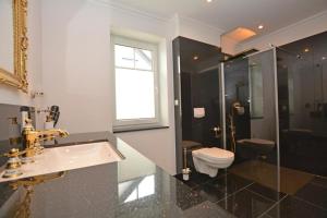 ein Badezimmer mit Waschbecken, Toilette und Dusche in der Unterkunft Ferienhaus Merzijana in Büsum