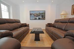 ein Wohnzimmer mit zwei braunen Sofas und einem Tisch in der Unterkunft Ferienhaus Merzijana in Büsum