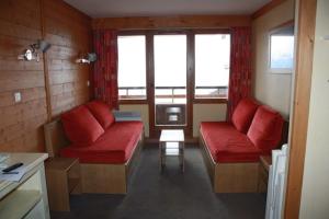 a room with two red couches and a table at L'ours blanc in LʼHuez