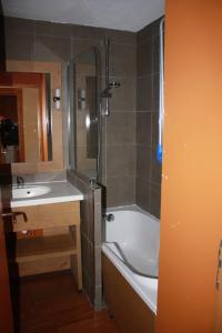 a bathroom with a shower and a sink and a tub at L'ours blanc in LʼHuez