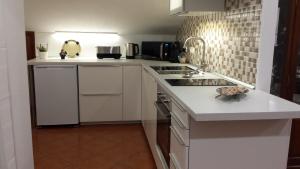 a kitchen with white cabinets and a counter top at Vista do Canal Plus in Horta