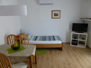 Habitación pequeña con cama, mesa y TV. en Apartments Toni, Borik, en Zadar
