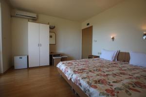 a bedroom with a large bed with a floral blanket at Guest House Kiwi in Golden Sands