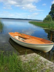 a boat sitting on the water next to a dock at Björboholm in Gråbo