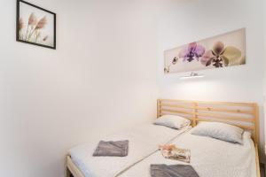ブダペストにあるFleur Créme Apartmentのベッドルーム1室(ベッド2台付)が備わります。壁に2枚の写真が飾られています。