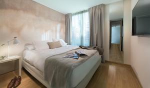 a bedroom with a large bed and a television at Zip Housing El Golf in Santiago