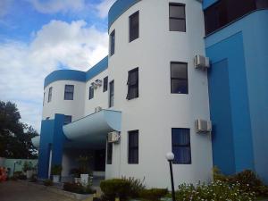 un edificio blanco y azul con un azul en Jacarandá Palace Hotel, en Teixeira de Freitas