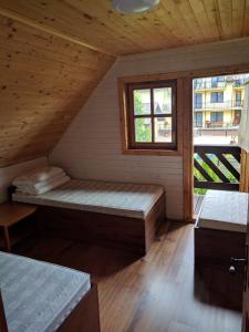 ヤストシェンビャ・グラにあるNoclegi U LISKAのベッドと窓が備わる小さな客室です。