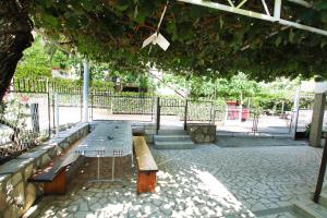 a bench sitting under a tree in a park at Guest House Bajceta in Herceg-Novi
