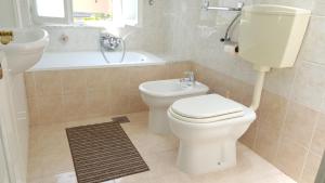uma casa de banho com um WC, um lavatório e uma banheira em Guest House Izola em Izola