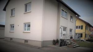 a white building with a staircase next to it at Ferienwohnung Hengl in Ettenheim