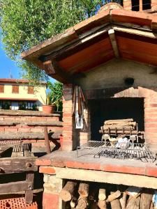 a patio with a grill with a bench on it at Villa Il Cipresso in Terranuova Bracciolini