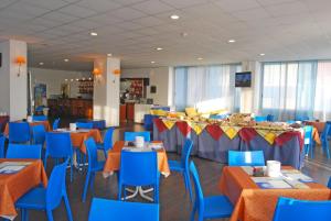 un comedor con mesas azules y sillas azules en Hotel Embassy, en Pesaro