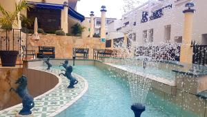 a swimming pool filled with water next to a fountain at Klayman Olivina Aparthotel in Los Cristianos