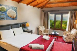 a bedroom with a bed and two chairs and a window at İstanbul Airport Durusu Club Hotel in Arnavutk&ouml;y