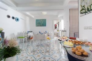 um quarto branco com uma mesa com comida em San Nicola B&B em Castellammare di Stabia